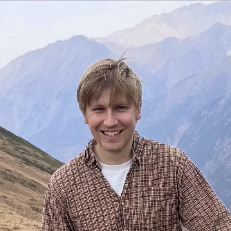 Phillip today, smiling in front of a mountain range